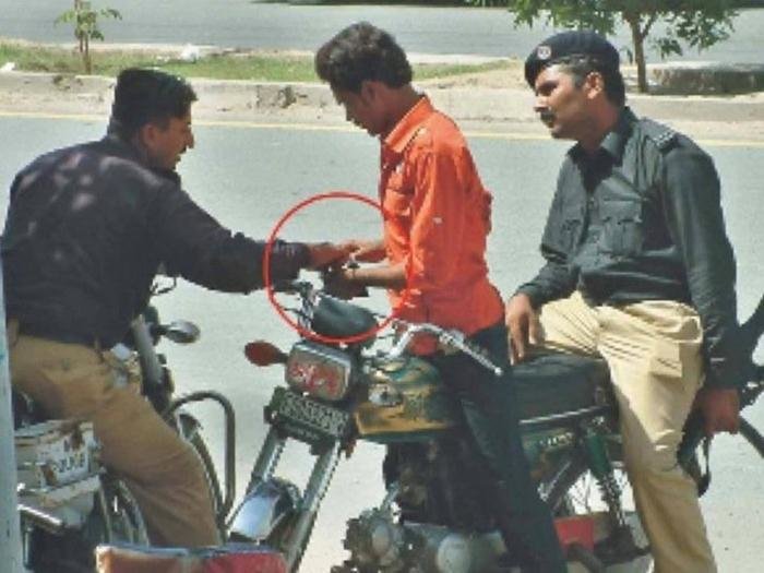 police officer taking money from a man on motor bike